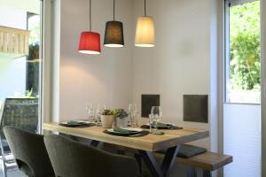 a dining room table with chairs and pendant lights at Ferienwohnung Am Kofel in Oberammergau