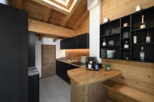 a kitchen with black cabinets and a wooden counter at Maisonette-Apartment Das Garmisch mit Whirlpool in Garmisch-Partenkirchen