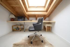 a chair in a room with a desk and a window at Maisonette-Apartment Das Garmisch mit Whirlpool in Garmisch-Partenkirchen