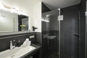 a bathroom with a sink and a shower and a mirror at Maisonette-Apartment Das Garmisch mit Whirlpool in Garmisch-Partenkirchen