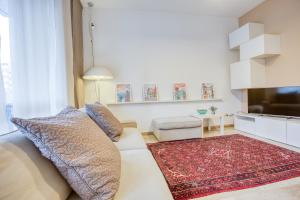 een woonkamer met een witte bank en een rood kleed bij Easylife - Milano - Morosini 32 - Porta Romana in Milaan