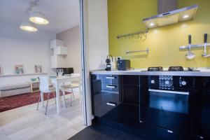 een keuken met zwarte apparatuur en een tafel met stoelen bij Easylife - Milano - Morosini 32 - Porta Romana in Milaan