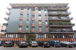 een hoog gebouw met auto's geparkeerd op een parkeerplaats bij Easylife - Milano - Morosini 32 - Porta Romana in Milaan