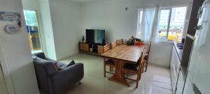 纳韦甘蒂斯Suíte 50 metros da praia, 10 km Beto Carrero e BC, local compartilhado的带木桌和沙发的客厅