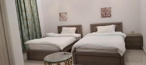 a room with two beds and a glass table at happy villa ras al khaimah chalet in Ras al Khaimah +43 photos