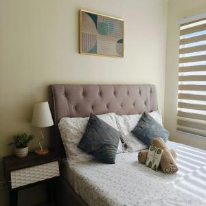 a bed with two pillows on top of it at Marina Shoreline Condotel- Dumaguete in Piapi