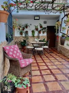a patio with a table and chairs and a table and chairs at Casa Almenta - Tu hogar para desconectar en el pueblo más bonito de Málaga in Benalauría