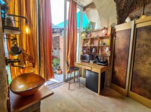 a room with a kitchen with a desk and a window at CasaRosada Healing and Wellness Retreat in Vidracco
