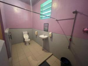 a small bathroom with a toilet and a sink at Osman homestay in Sukau
