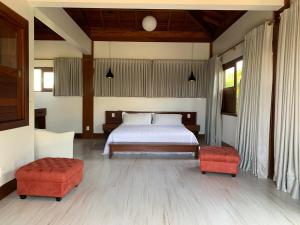 una camera con un letto e due pouf rossi di Casa do Sol - Praia do Forte a Mata de Sao Joao Altre 22 foto