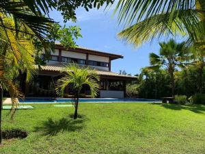 un resort con piscina e palme di Casa do Sol - Praia do Forte a Mata de Sao Joao