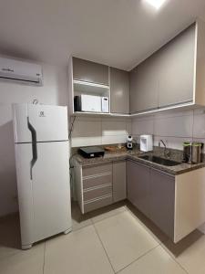a kitchen with a white refrigerator and a sink at Apartamento no Shopping em Brasília DF in Brasilia