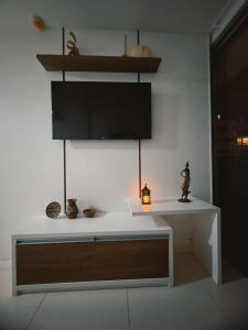 a white table with a tv on a wall at Apartamento no Shopping em Brasília DF in Brasilia +5 photos