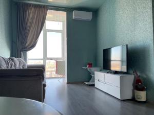 ein Wohnzimmer mit einem Flachbild-TV auf einem weißen Schrank in der Unterkunft Видовые апартаменты рядом клиника Рахманова in Dnipro