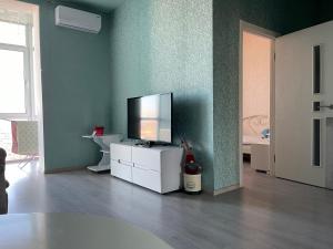 ein Wohnzimmer mit einem Flachbild-TV auf einem weißen Schrank in der Unterkunft Видовые апартаменты рядом клиника Рахманова in Dnipro