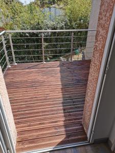 a wooden deck on the side of a house at Appartement au coeur des vignes region pic st Loup in Claret