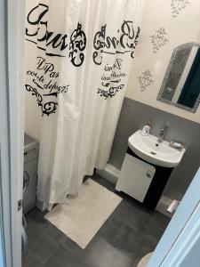 ein Badezimmer mit Waschbecken und Duschvorhang in der Unterkunft Видовые апартаменты рядом клиника Рахманова in Dnipro + 2 Fotos