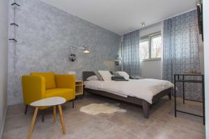 1 dormitorio con 1 cama y 1 silla amarilla en B&B Vibe, en Split