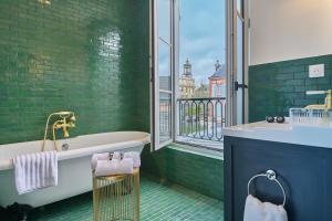 un bagno verde con vasca e finestra di Maleyssie Les Suites a Chartres Altre 92 foto