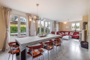 a dining room with a table and chairs and a couch at Villa Mara Mit 5 Schlafzimmern in Glowe +21 photos
