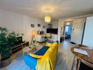 a living room with a yellow couch and a table at Au bord de l'eau in Concarneau