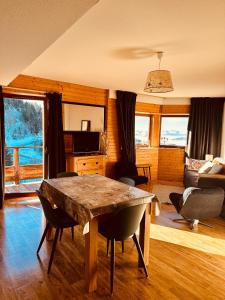 a living room with a wooden table and a couch at "La Croix", Appartement 4 personnes, les Balcons de Recoin in Chamrousse +18 photos