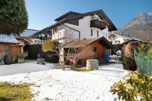 a large white house with a tree in a yard at Haus Riedel in Garmisch-Partenkirchen