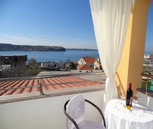 Una botella de vino sentada en una mesa en un balcón en Appartement Lemi Mit Meerblick, en Ražanac