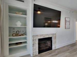 a living room with a fireplace and a flat screen tv at Adagio #403B in Santa Rosa Beach