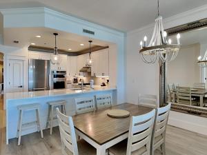a kitchen and dining room with a wooden table and chairs at Adagio #403B in Santa Rosa Beach +29 photos