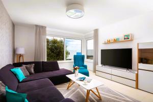 a living room with a purple couch and a tv at Luxuriöse Villa Dolce Vita Direkt Am Meer Mit Privatem Pool Und Parkplatz in Sevid