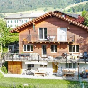uma grande casa de madeira com uma varanda e uma mesa em Apartment Bergzauber em Amden