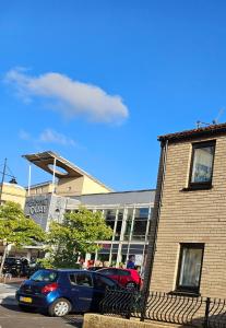 a blue car parked in front of a building at Inspire Home Stylish Stay B in Cardiff