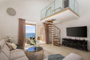 un soggiorno con scala a chiocciola e TV di Seaside Luxury Villa Castello Rogoznica Heated Pool, Sauna, Gym & Jacuzzi a Rogoznica (Rogosnizza)