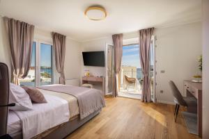 una camera da letto con un letto e vista sull'oceano di Seaside Luxury Villa Castello Rogoznica Heated Pool, Sauna, Gym & Jacuzzi a Rogoznica (Rogosnizza) Altre 112 foto