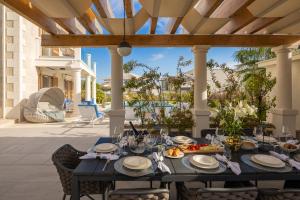 un tavolo da pranzo sul patio di una villa di Seaside Luxury Villa Castello Rogoznica Heated Pool, Sauna, Gym & Jacuzzi a Rogoznica (Rogosnizza)