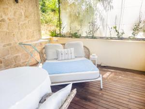 a bed and a couch in a room with a window at ECO Aparthotel The Dreamers's Club in Lumbarda