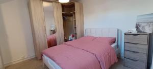 ein Schlafzimmer mit einem rosa Bett und einer Kommode in der Unterkunft La Pivoine in Trouville-sur-Mer