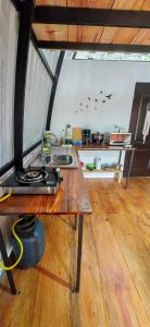 a kitchen with a table with a stove in a room at Cabaña el Chapuzón montaña y rio, lugar fresco in Cedral