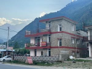 a building on the side of a street with mountains at Niwas Homestay Katrain in Kulu