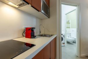 a kitchen with a sink and a red appliance on a counter at Darsena Flat in Milan +28 photos