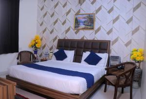 马图拉Hotel Panache 500 Mtrs From Shri Krishna Janma bhumi Teample的卧室里有一张大床，配有蓝色枕头