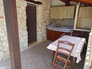 eine Küche mit einem Tisch und einem Tisch und ein Zimmer mit einem Bett in der Unterkunft BLUIAIA CASE VACANZE TROPEA in Caria