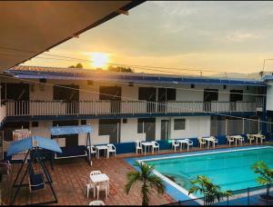 a hotel with a pool and chairs and a building at Hotel Girardot La Ciudad Del Sol in Girardot