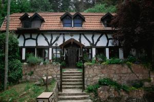 ein Haus mit einer Steinmauer und einer Tür in der Unterkunft Apart del Bosque La Cumbrecita in La Cumbrecita