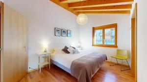 a bedroom with a white bed and a yellow chair at Perce Neige SUBLIME & VIEW apartments by Alpvision Résidences in Veysonnaz