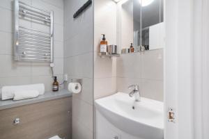 a white bathroom with a sink and a mirror at Executive Sloane Apartment 810 in London