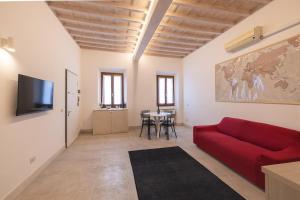 Una sala de estar con un sofá rojo y una mesa. en Villa Strozzi Travel Apartment, en Florencia