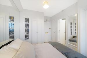 a white bedroom with a bed in a room at Executive Sloane Apartment 810 in London