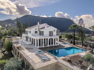 a large white house with a swimming pool and mountains at Great property - amazing views in Limassol